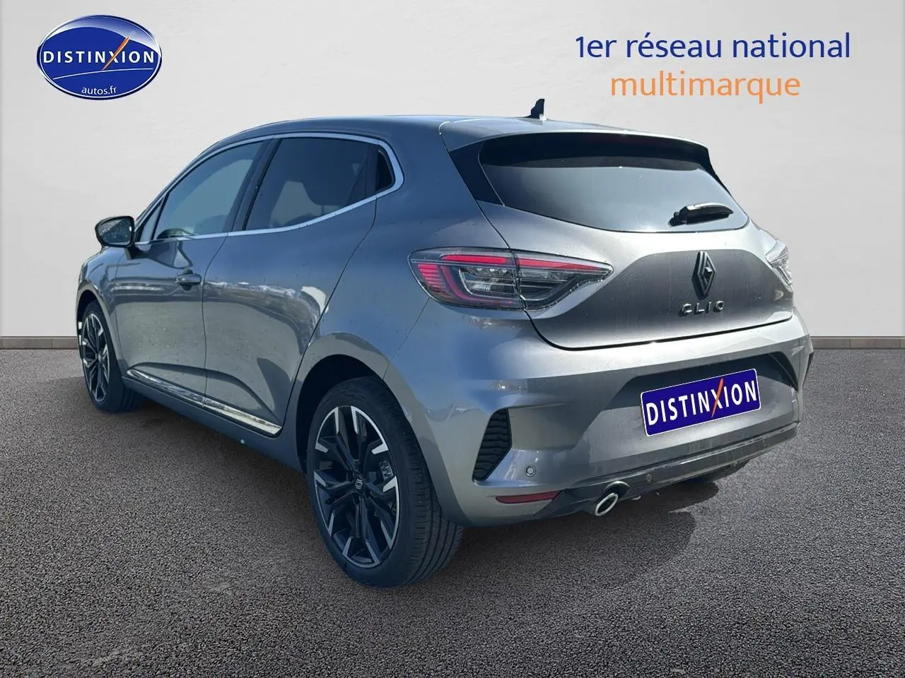 Renault Clio V gris schiste vue 3/4 arrière droit, jantes alu noires et feux arrière LED distinctifs.