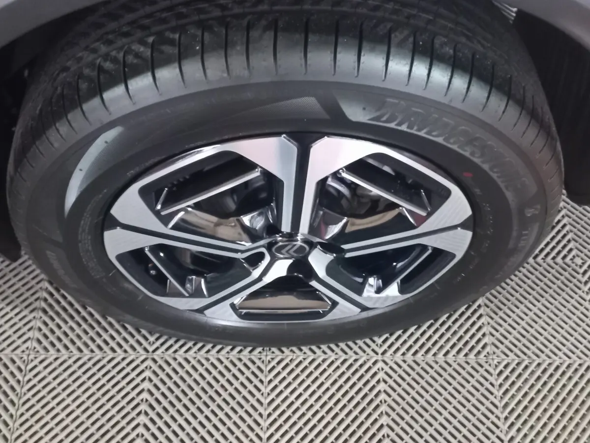 Gros plan sur la roue avant droite de la Citroën C3 hybride 2025 avec jante alliage bicolore et pneu Bridgestone.