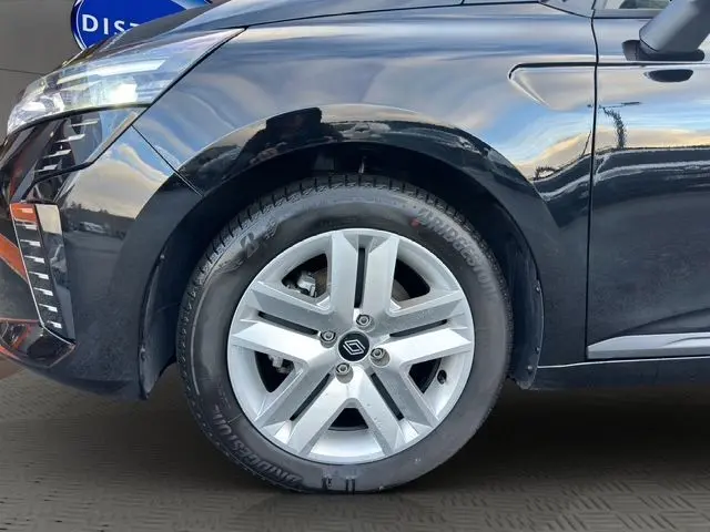 Vue de profil côté avant gauche d'une Renault Clio V noire avec phares LED et jante partiellement visible.