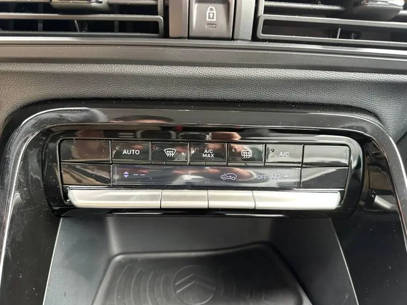 Vue rapprochée de la console centrale noire brillante avec commandes climatisation tactile de la Citroën C3 électrique 2025.