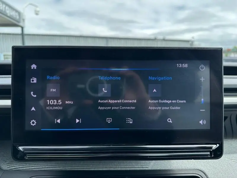 Écran tactile central affichant radio, téléphone et navigation dans l’habitacle d’une Citroën C3 électrique noire.