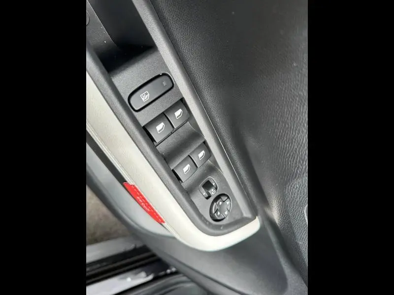 Gros plan sur les commandes des vitres et rétroviseurs côté conducteur de la Citroën C3 électrique 2025 en Noir Perla Nera.