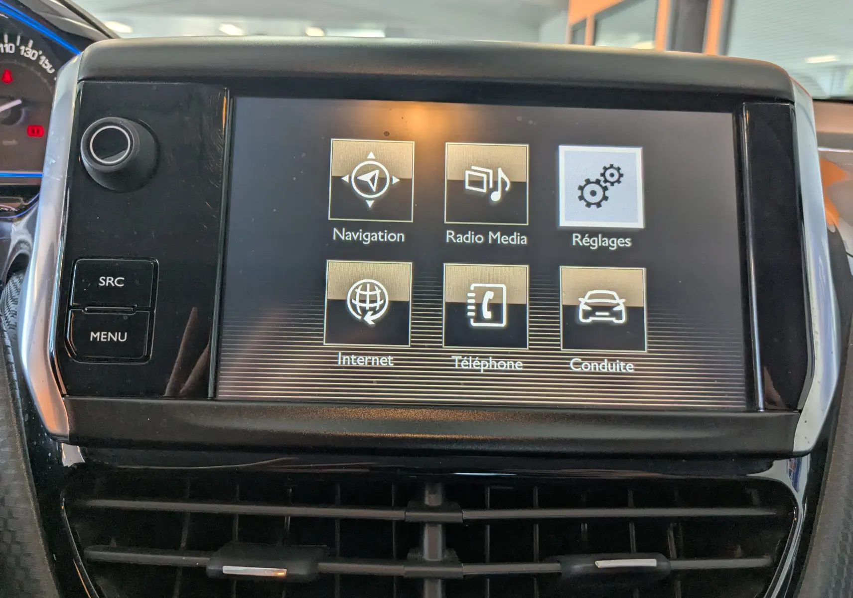 Écran tactile central du tableau de bord du Peugeot 2008 gris, affichant les options Navigation, Radio, Réglages, Internet, Téléphone et Conduite.
