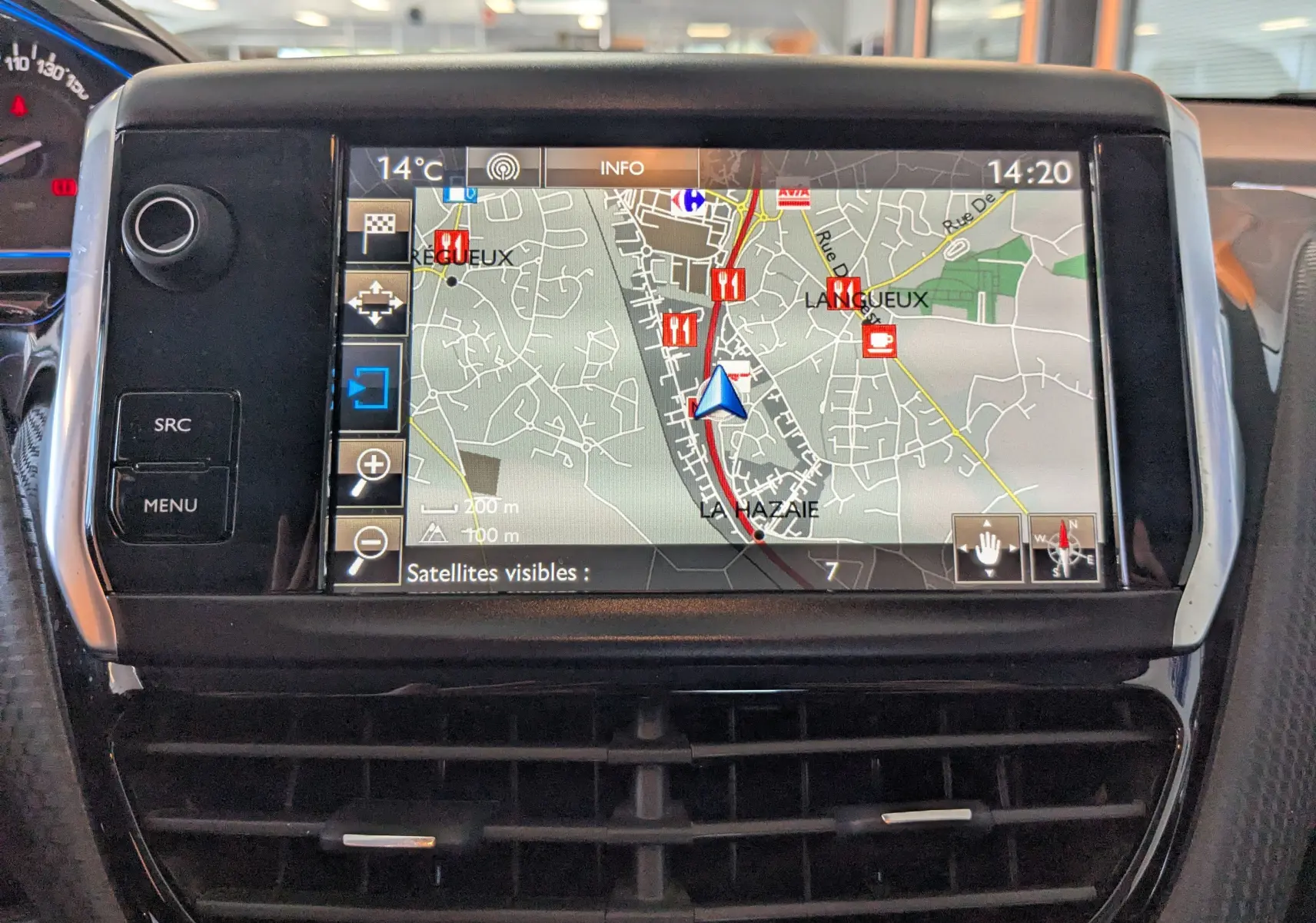 Écran tactile GPS en gros plan sur le tableau de bord d’une Peugeot 2008 gris Artense, affichant une carte détaillée.