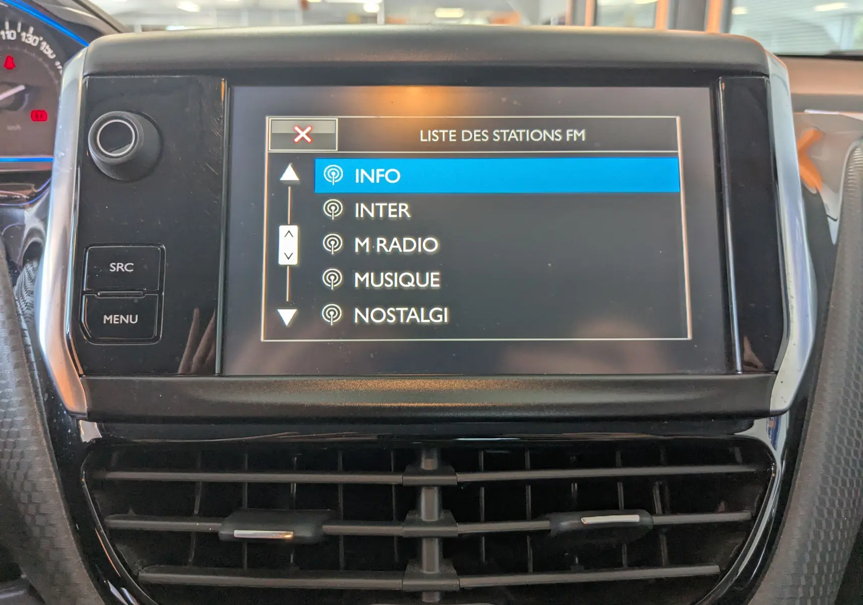 Vue rapprochée de l’écran central tactile du Peugeot 2008 1.6 BlueHDi 120 Allure, affichant la liste des stations FM.