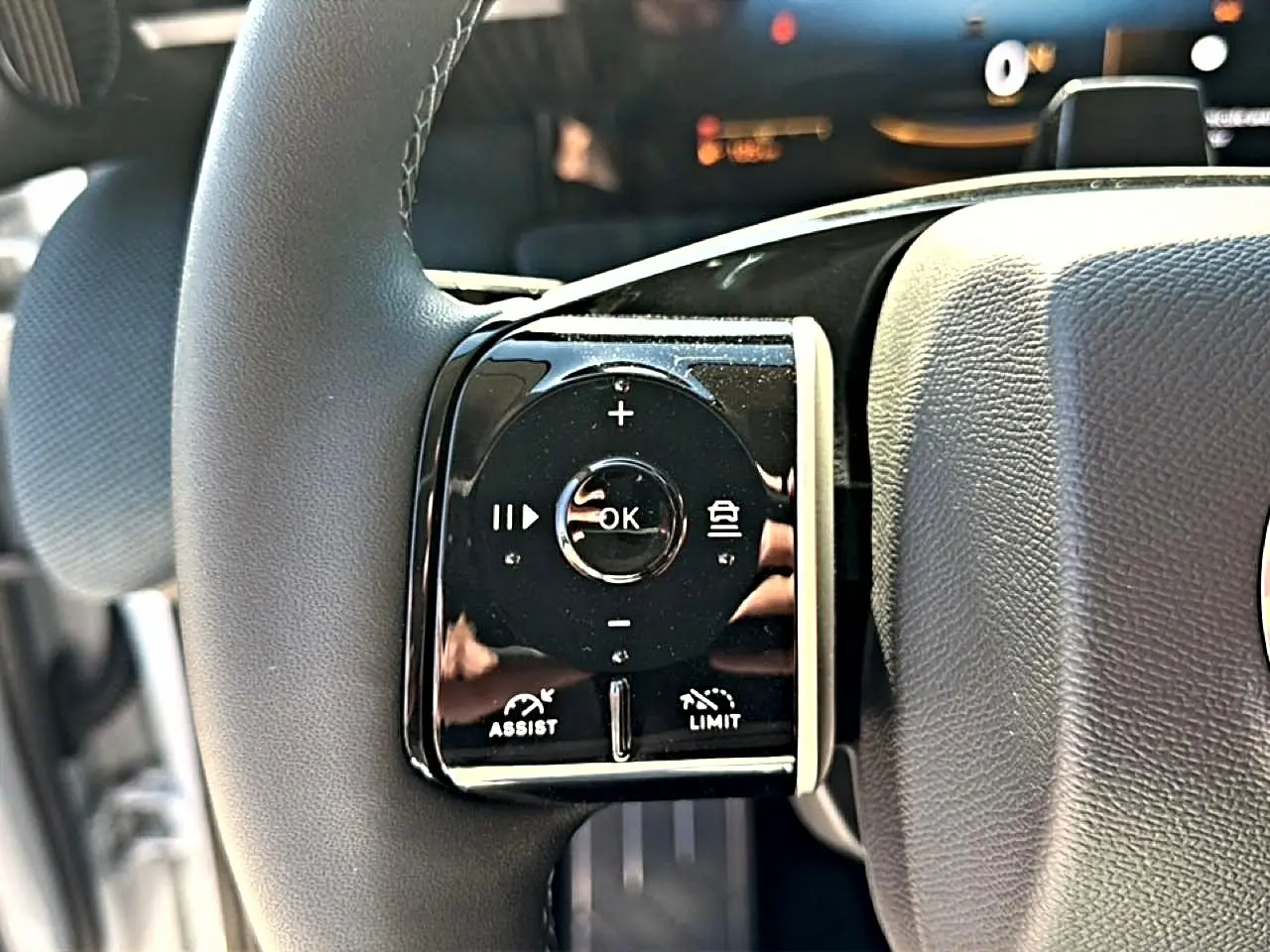 Gros plan sur les commandes multifonctions du volant côté gauche du Citroën C5 Aircross hybride blanc et noir.