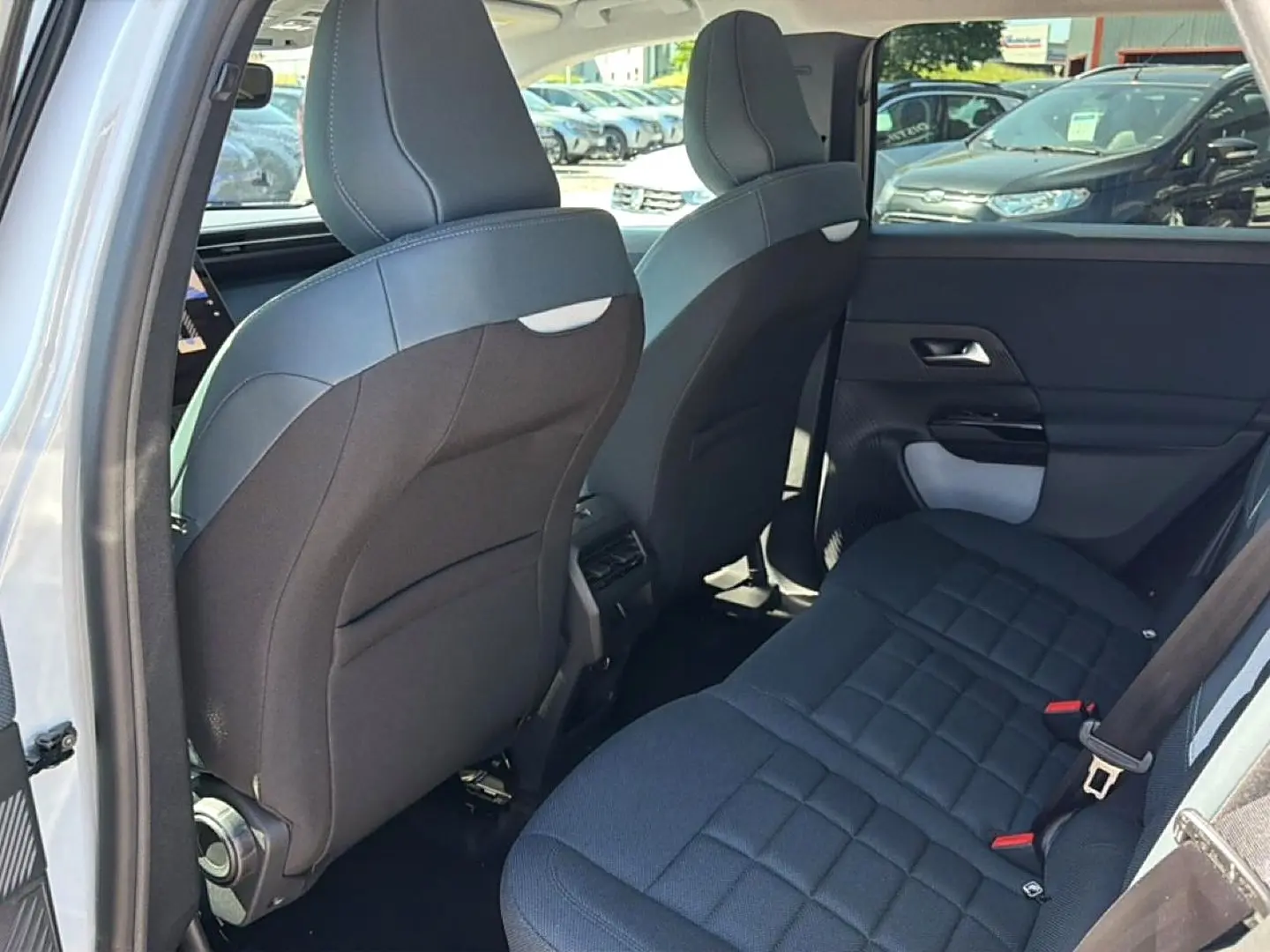Vue intérieure arrière côté gauche du Citroën C5 Aircross blanc, montrant les sièges arrière et le dossier des sièges avant noirs.