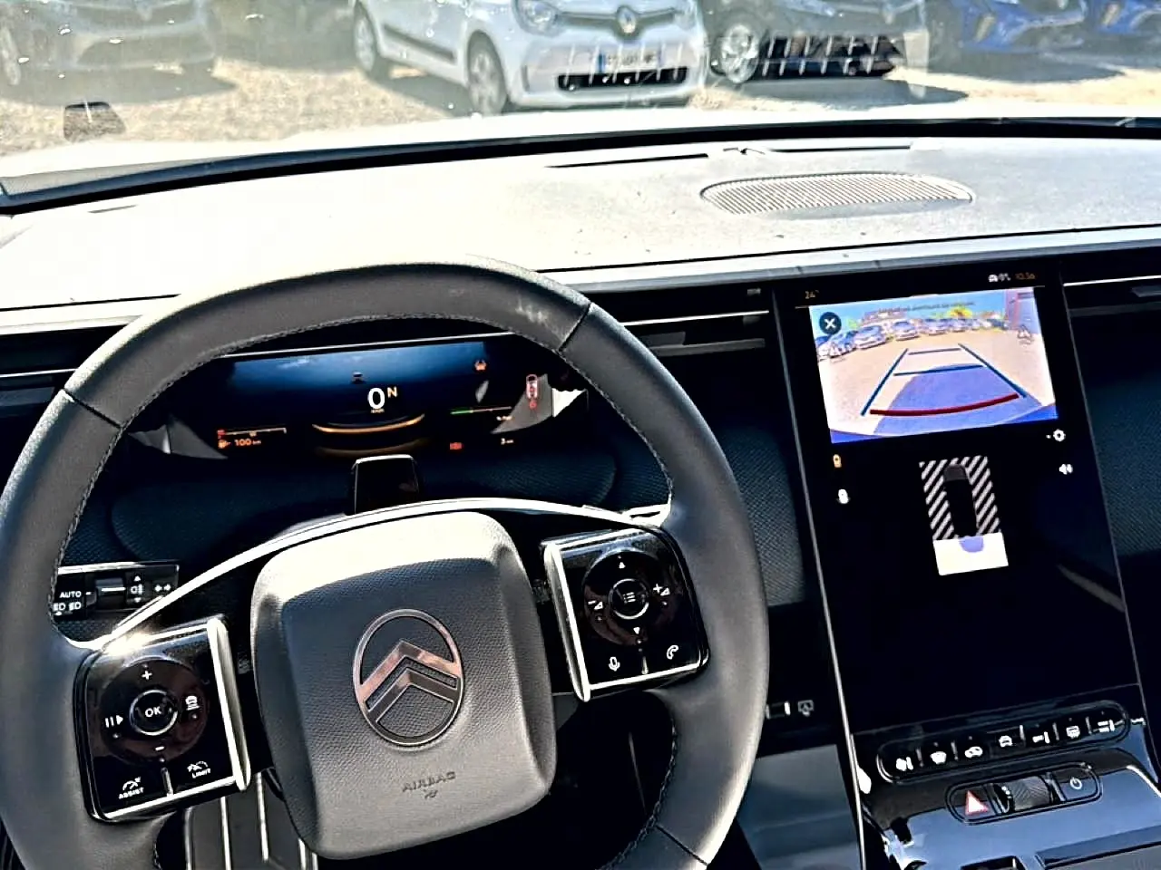 Vue intérieure centrée sur le volant noir multifonction et l'écran tactile affichant la caméra de recul du Citroën C5 Aircross.