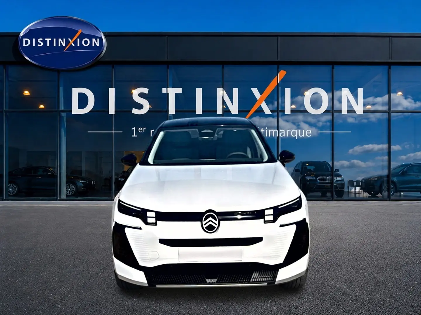 Vue de face du Citroën C5 Aircross 2026 blanc avec toit noir, devant une vitrine Distinxion.
