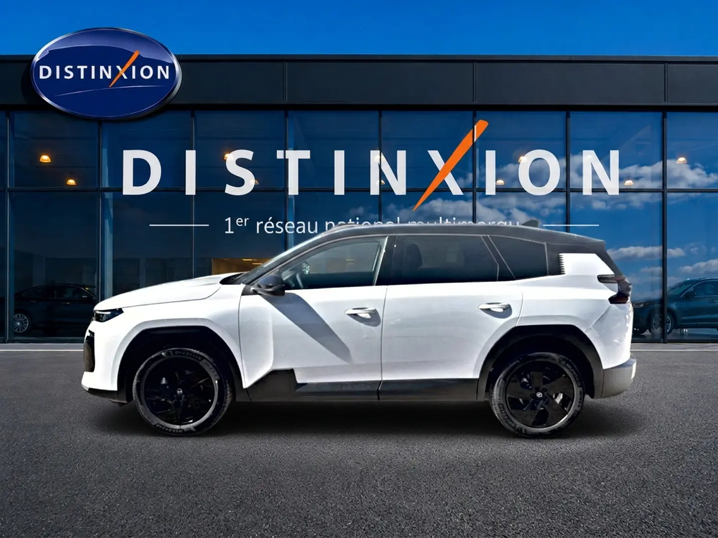Profil droit du Citroën C5 Aircross 2026 blanc avec toit noir et jantes alliage noires devant une vitrine Distinxion.