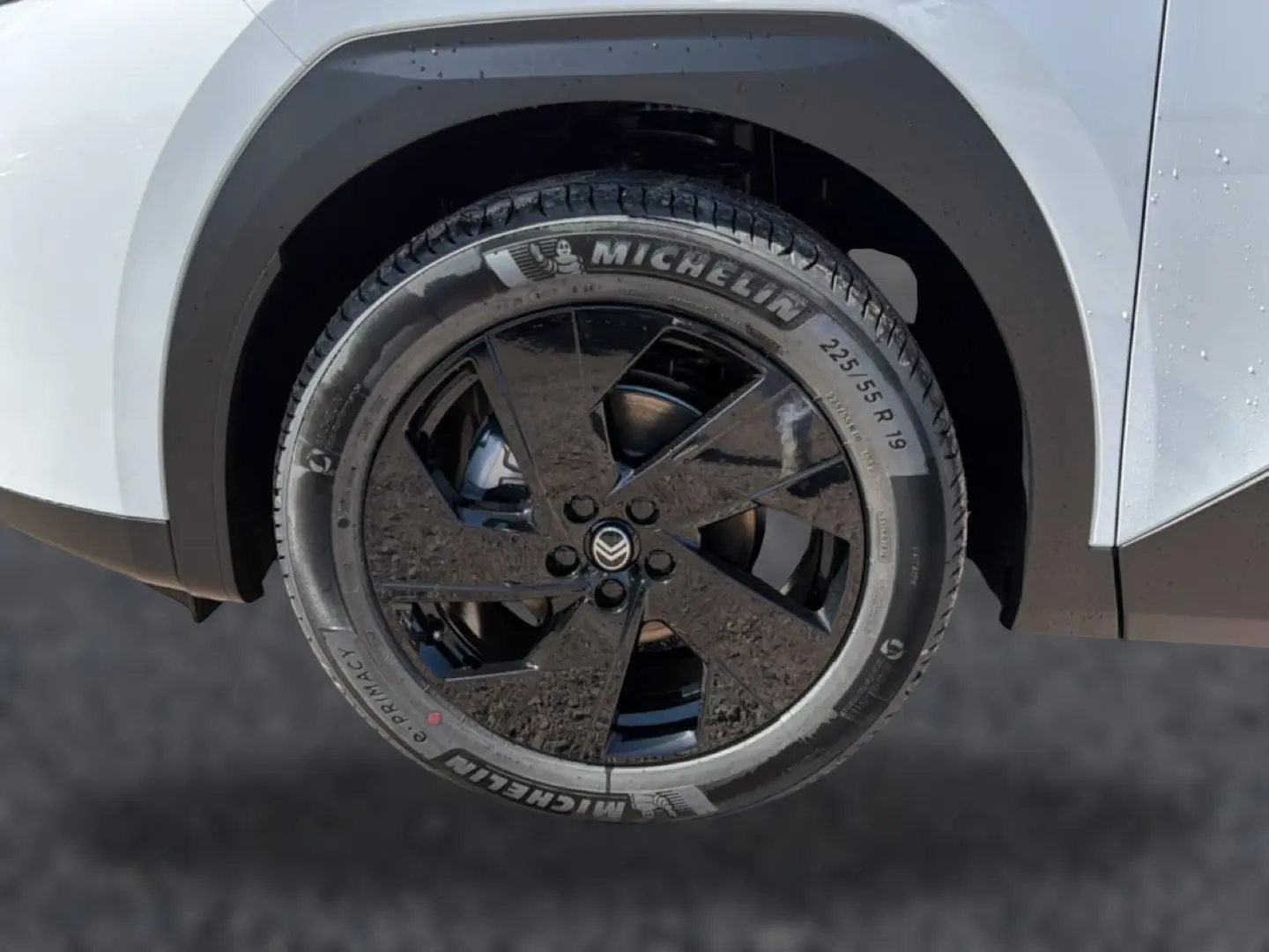 Gros plan sur la roue avant gauche noire et jante alliage 19 pouces du Citroën C5 Aircross blanc et noir.