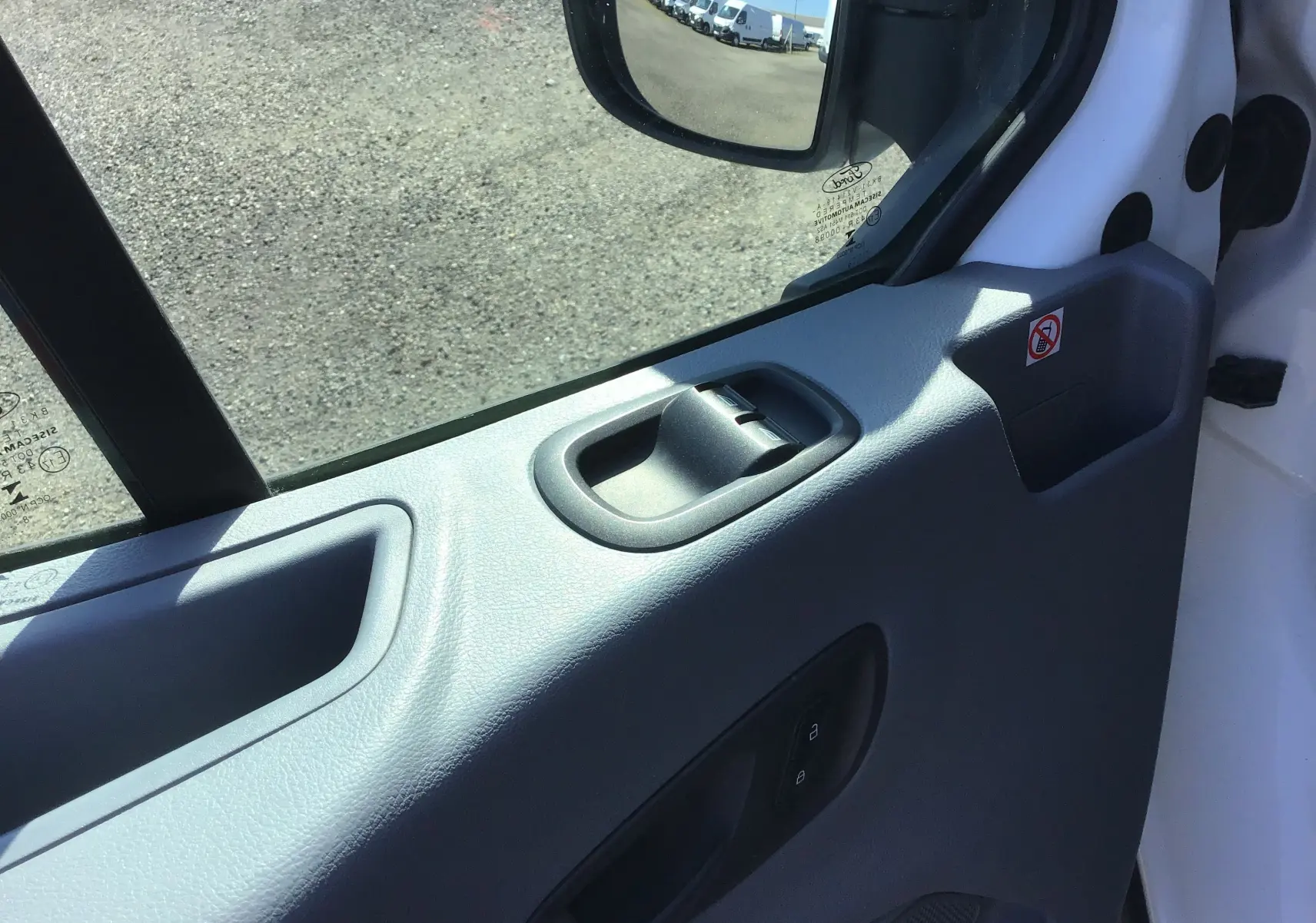 Vue rapprochée de la portière côté gauche du Ford Transit Châssis Cabine blanc, montrant la poignée et le rétroviseur électrique.