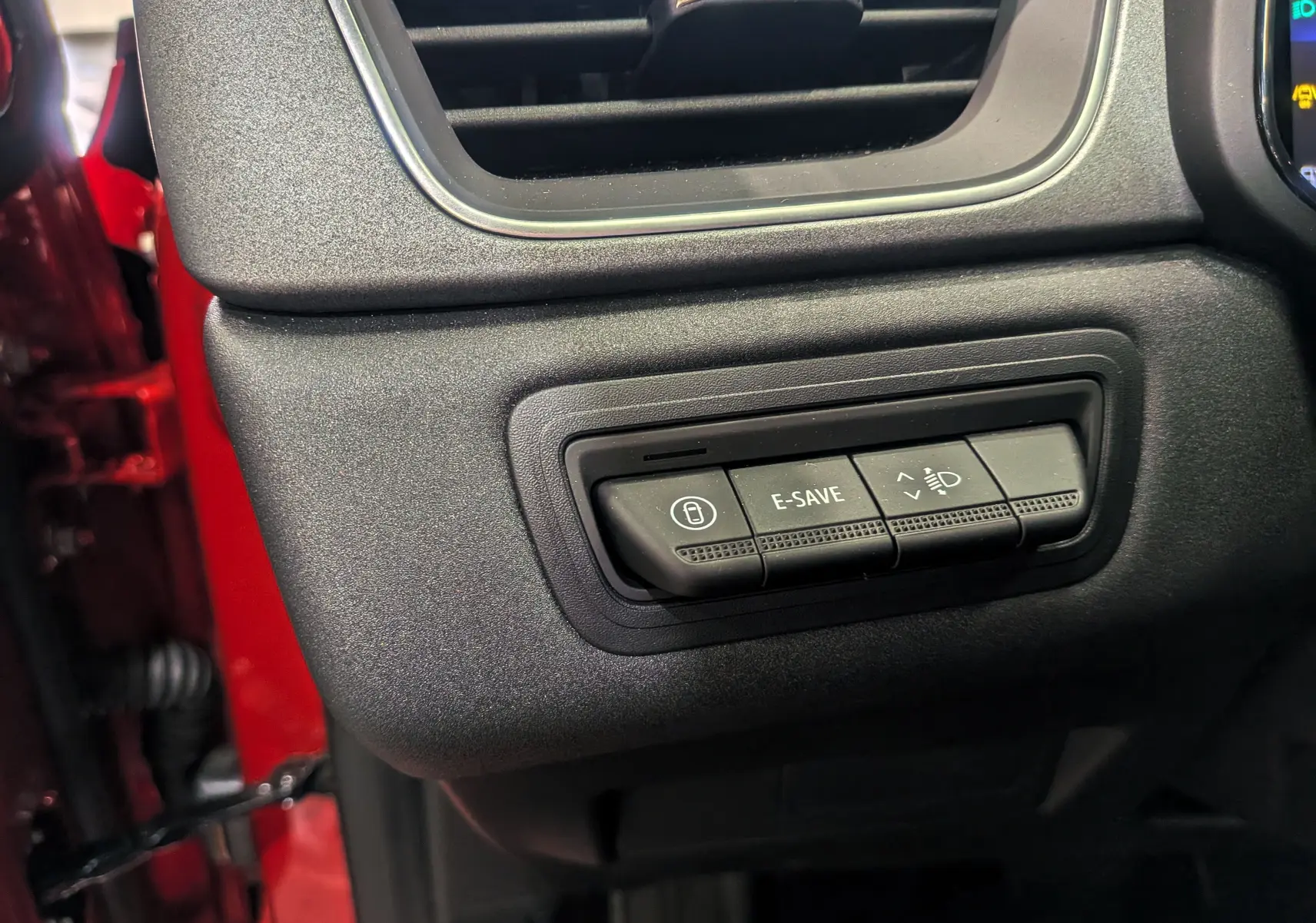 Boutons de commande E-SAVE et réglage des phares sur le tableau de bord du Renault Captur rouge Flamme 2025.