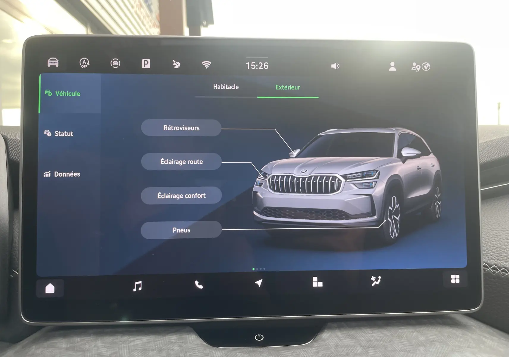 Écran tactile affichant une vue 3/4 avant argentée du Skoda Kodiaq avec indications sur rétroviseurs et éclairages.
