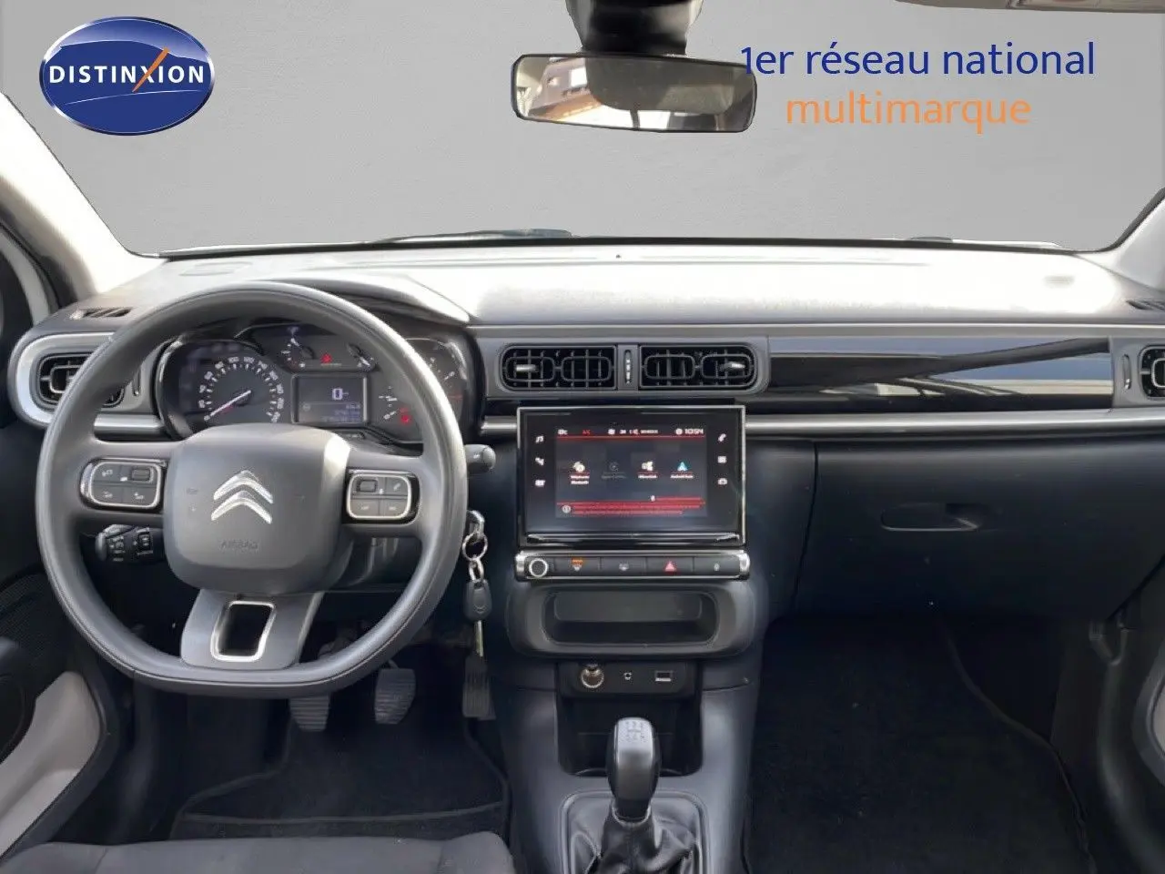 Vue intérieure frontale du tableau de bord noir de la Citroën C3 2018 avec volant multifonction et écran tactile central.