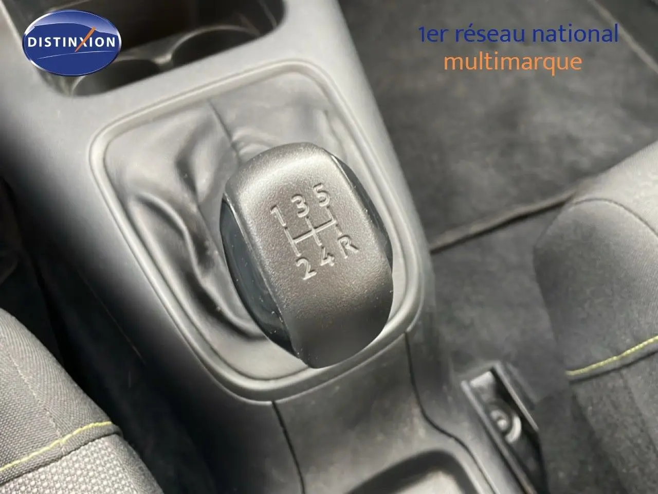 Gros plan sur le levier de vitesses manuel d'une Citroën C3 blanc toit rouge, intérieur tissu noir.