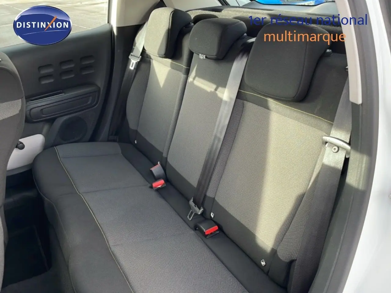 Vue intérieure des sièges arrière en tissu gris foncé de la Citroën C3 blanche avec toit rouge, version 2018.