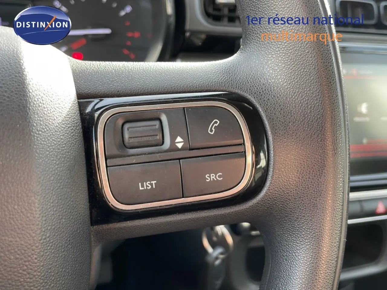 Gros plan sur les commandes au volant noir de la Citroën C3 2018, version 1.2 PureTech, essence, avec boutons de gestion audio et appel.