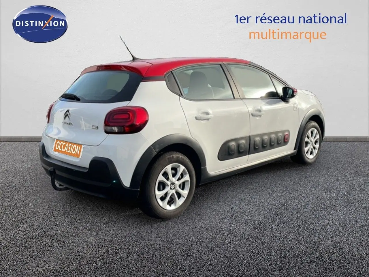 Vue 3/4 arrière droite d'une Citroën C3 blanche au toit rouge avec protections Airbump noires sur les portières.