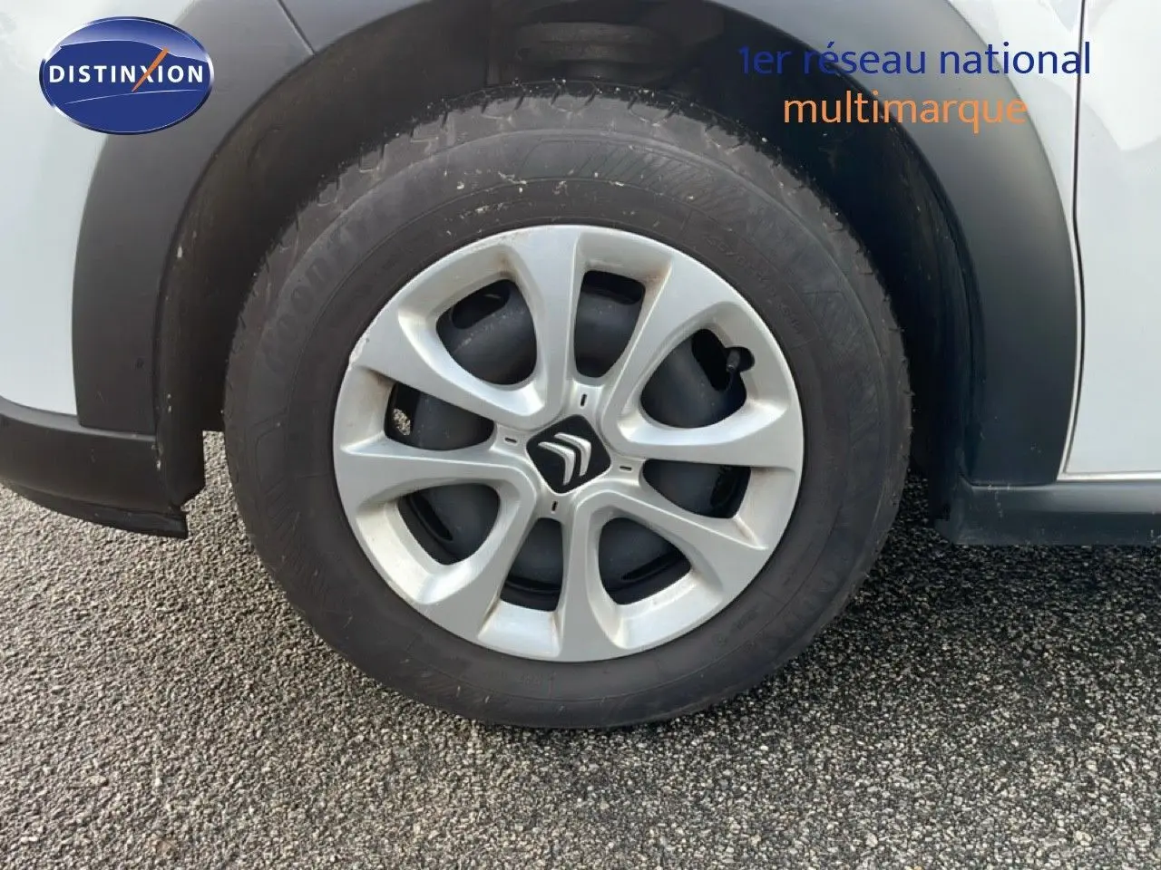 Gros plan sur la roue avant gauche d'une Citroën C3 blanche avec jante en alliage et logo Citroën central.