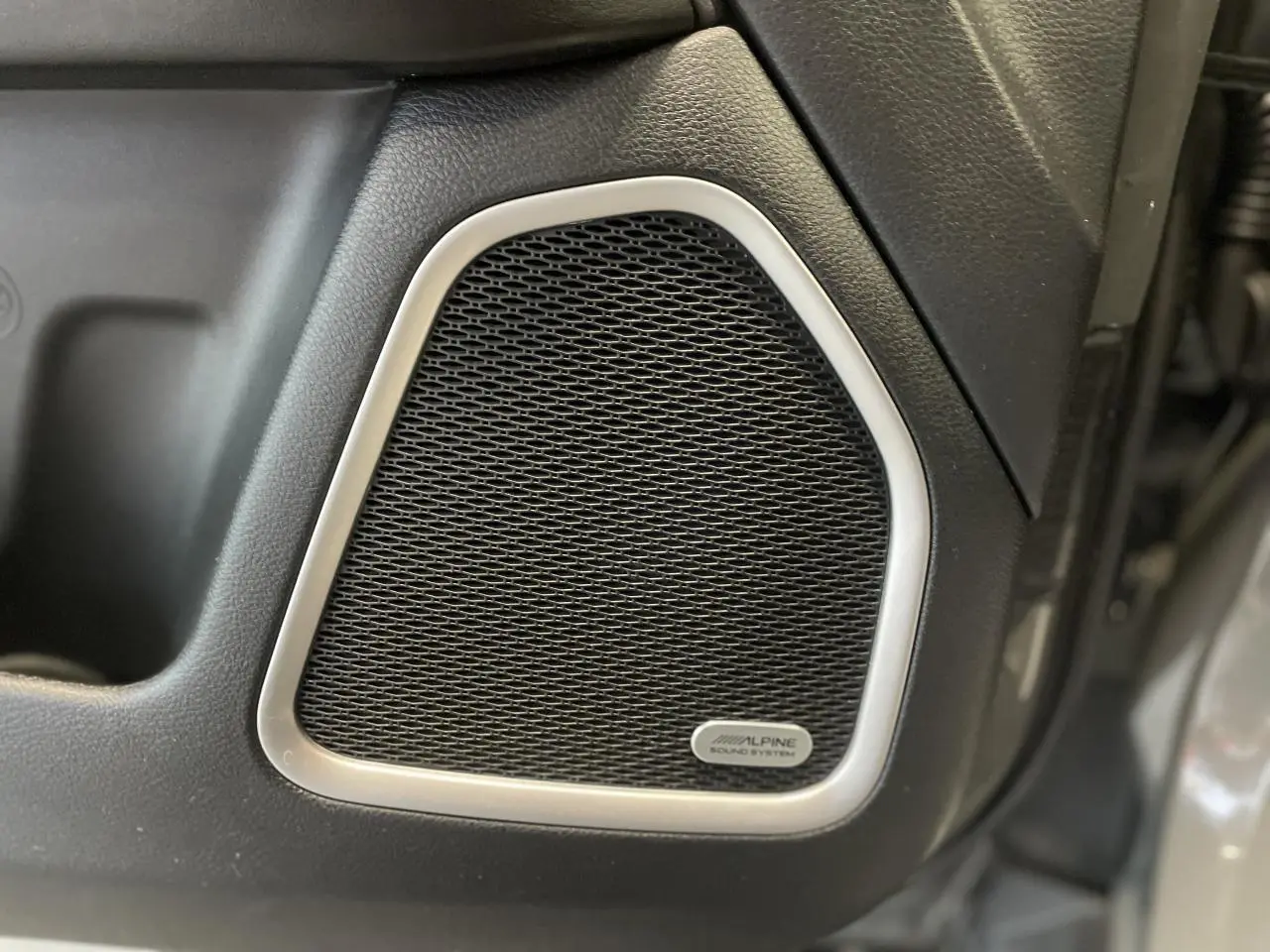 Gros plan sur l'enceinte Alpine intégrée à la porte côté droit du Jeep Compass gris foncé Trailhawk 2021.