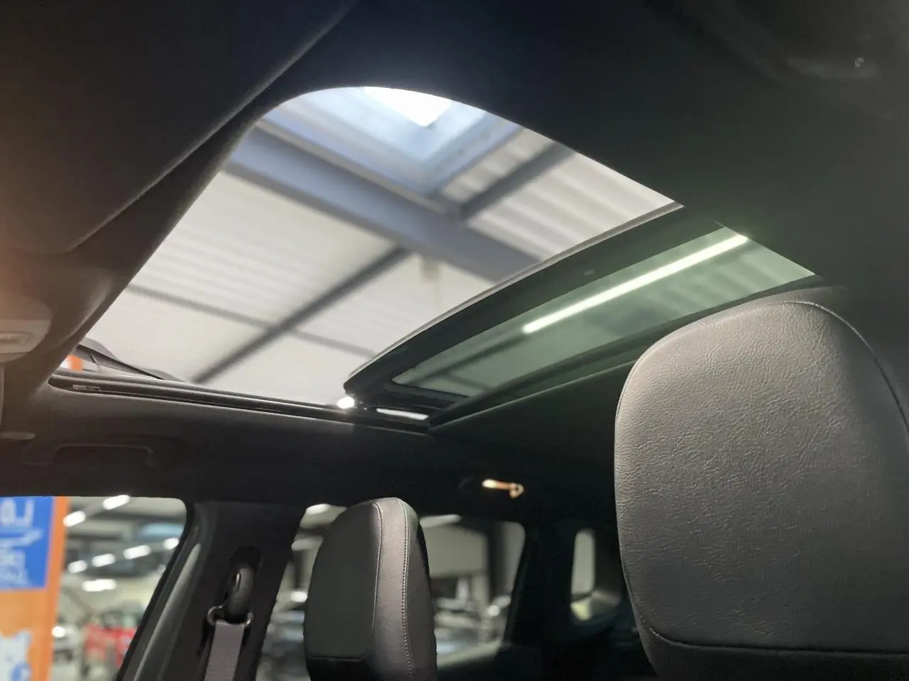 Vue intérieure du toit ouvrant panoramique CommandView du Jeep Compass Trailhawk avec sièges cuir noirs.