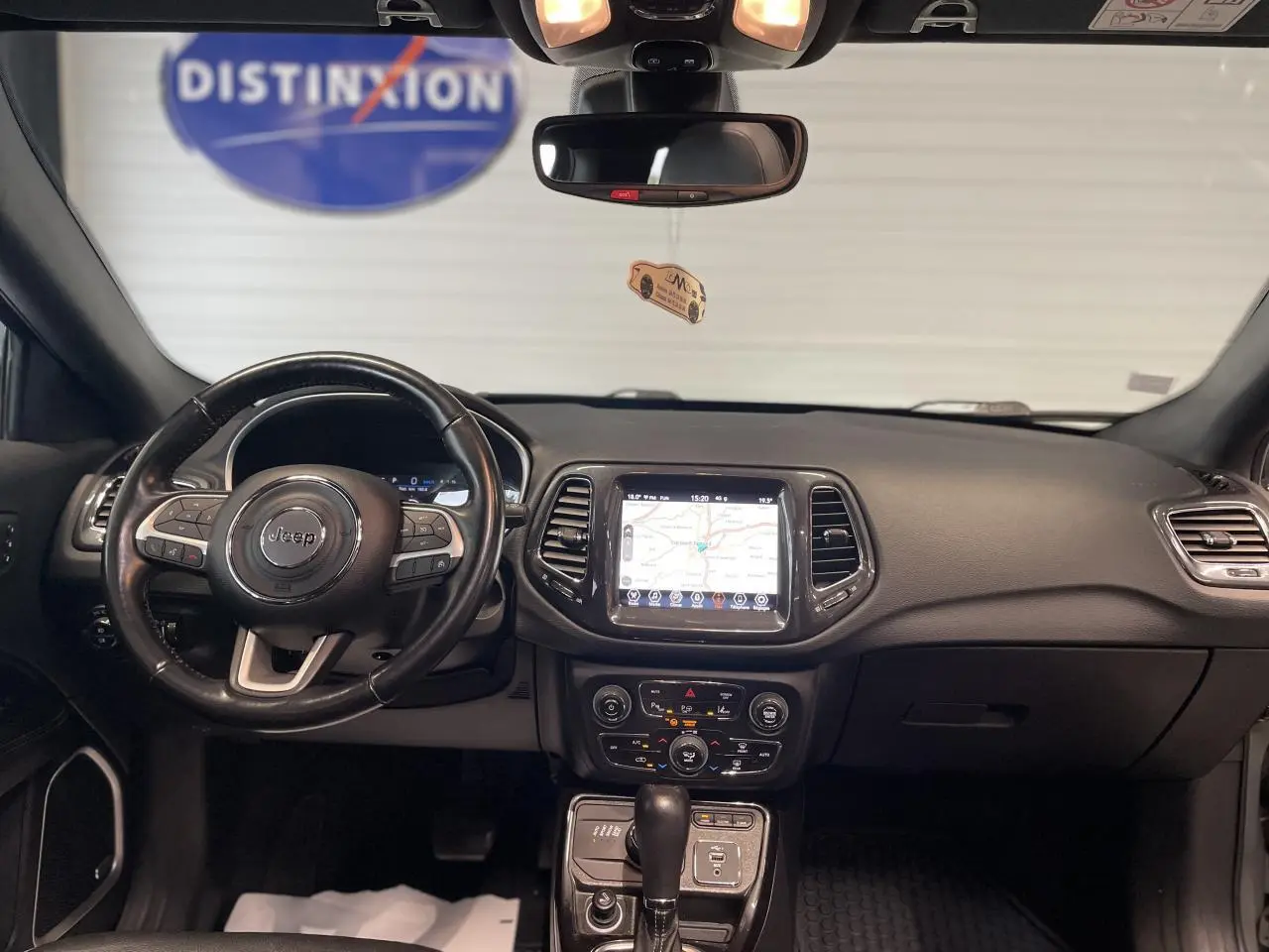 Intérieur noir du Jeep Compass 2021 vu de face, tableau de bord avec écran tactile GPS et volant cuir multifonction.