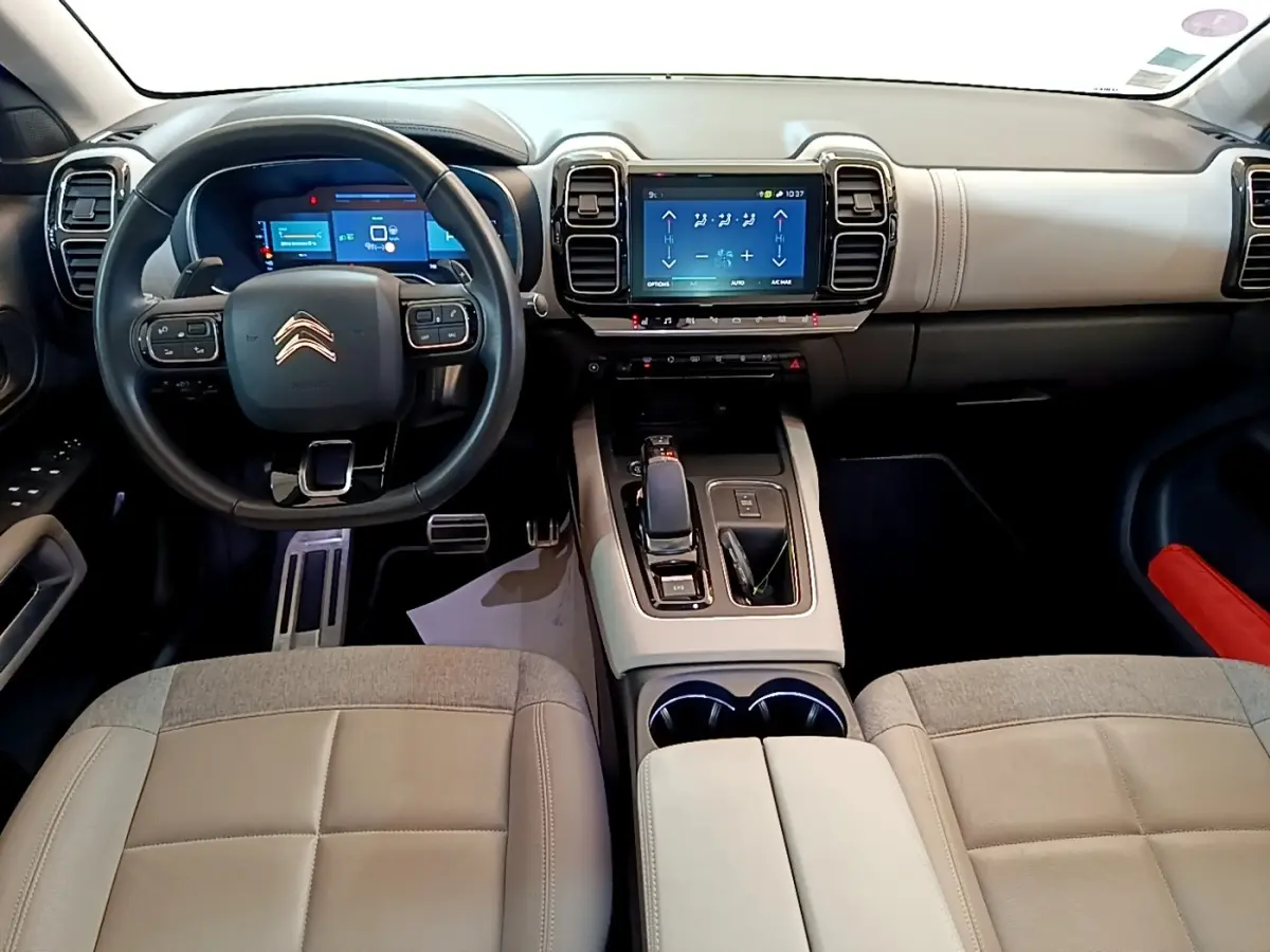 Vue intérieure avant du Citroën C5 Aircross Hybrid blanc, avec tableau de bord numérique et écran tactile central.