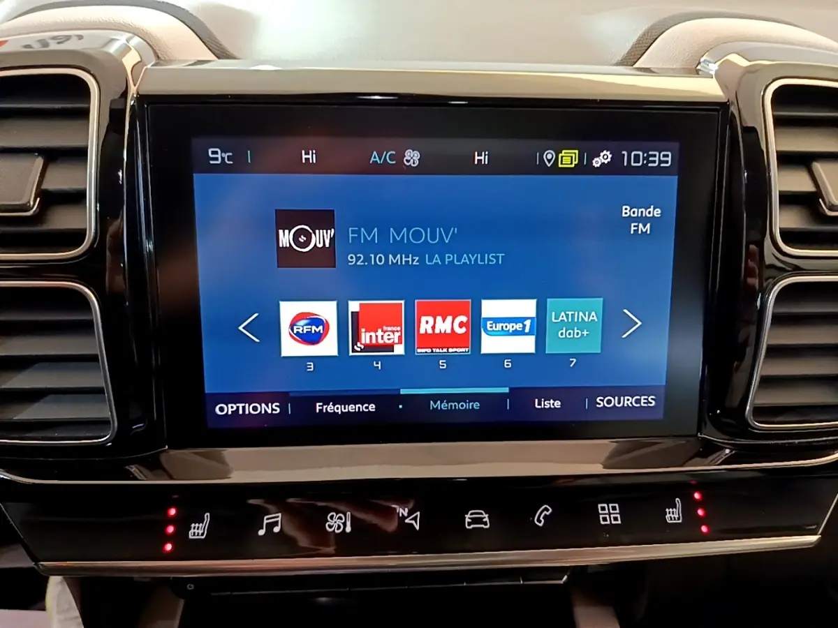 Écran tactile central affichant les stations radio dans l'habitacle du Citroën C5 Aircross blanc Hybrid 225 Shine Pack.