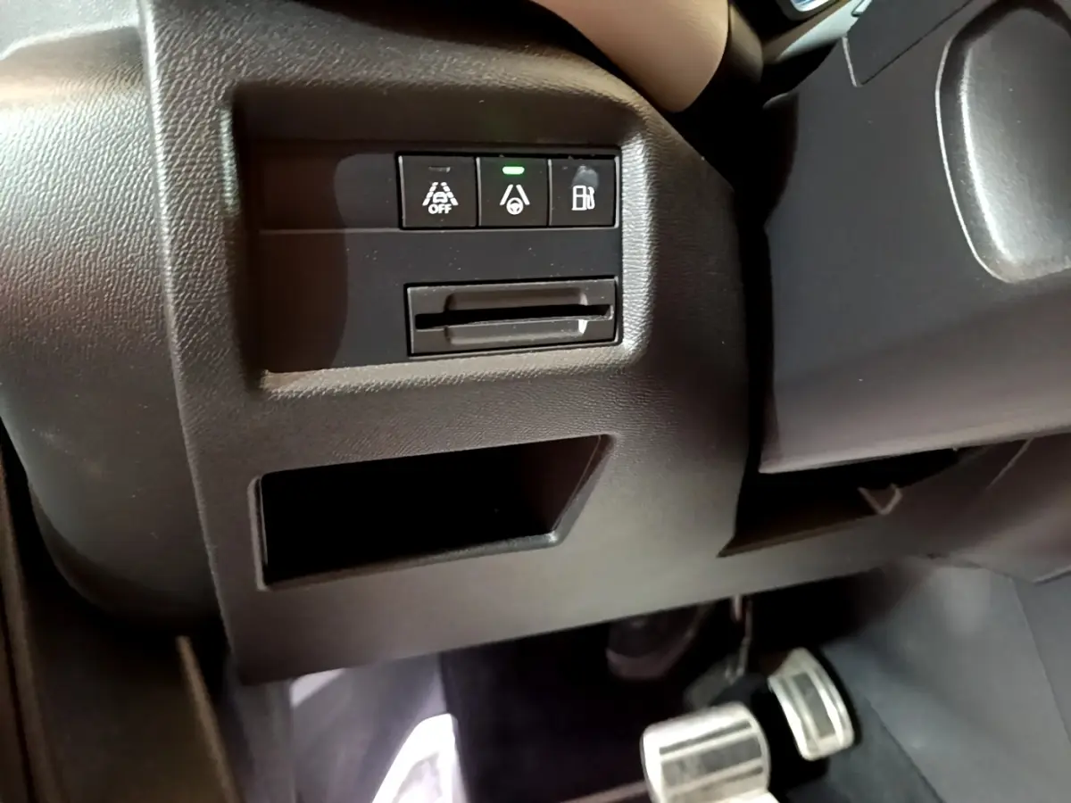 Détail intérieur côté gauche montrant les commandes d'assistance et la pédale dans un Citroën C5 Aircross Hybrid blanc.