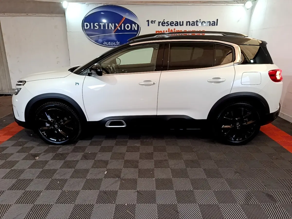 Vue latérale droite d'un Citroën C5 Aircross Hybrid blanc avec toit noir et jantes noires brillantes.