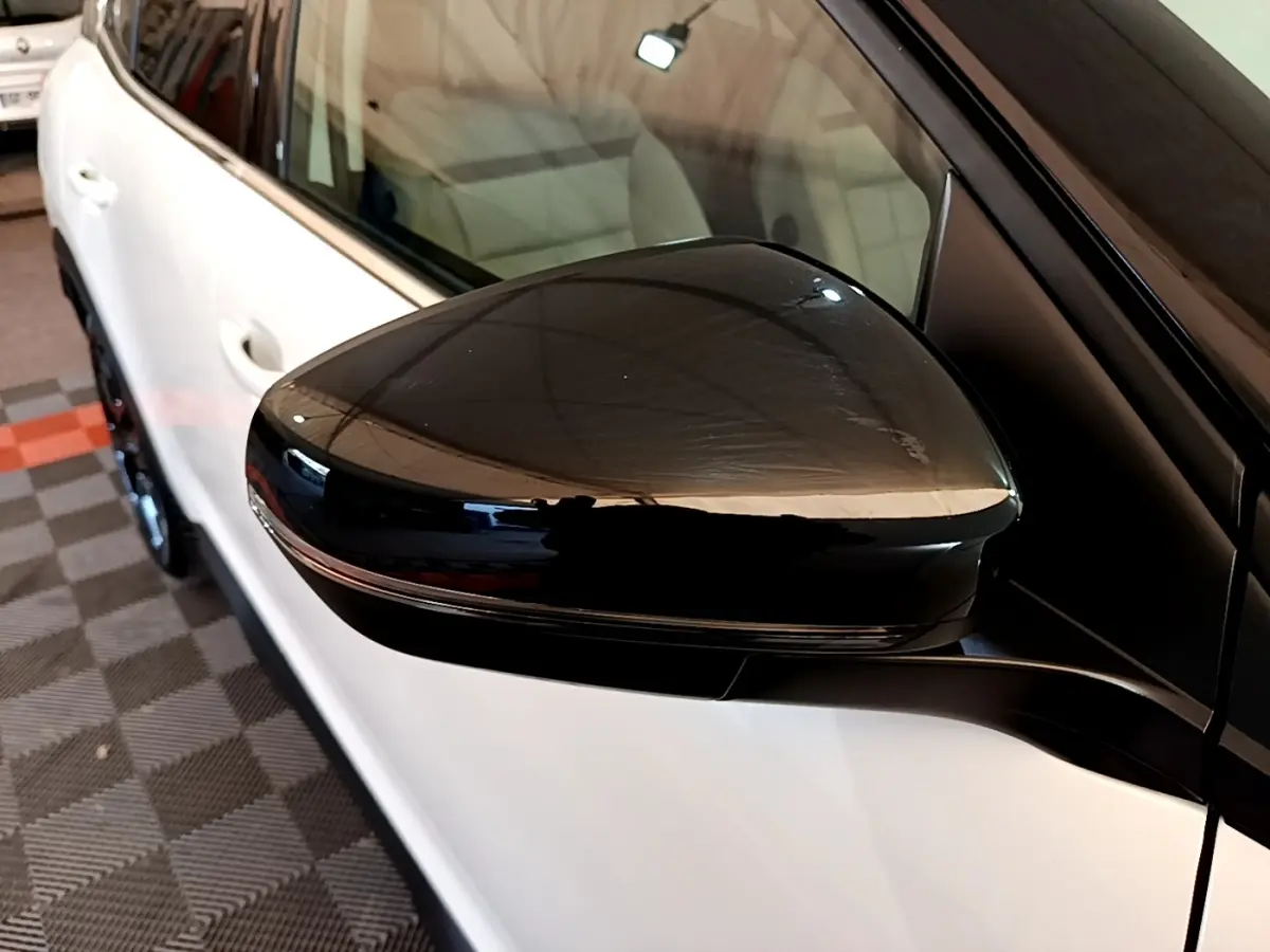 Rétroviseur noir en gros plan côté gauche d’un Citroën C5 Aircross blanc, vue partielle latérale.
