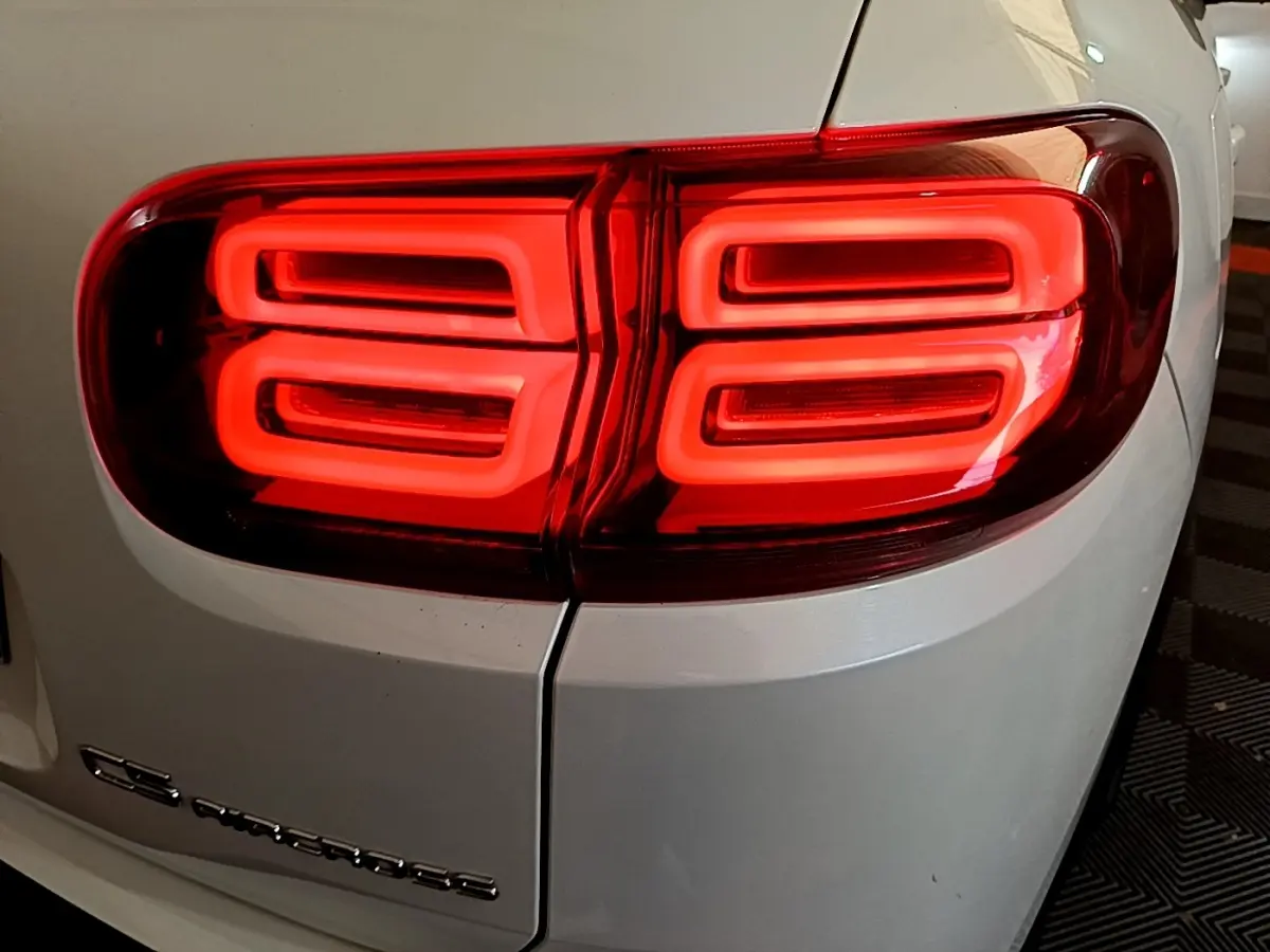 Gros plan sur le feu arrière droit rouge vif d’un Citroën C5 Aircross blanc, soulignant son design lumineux distinctif.