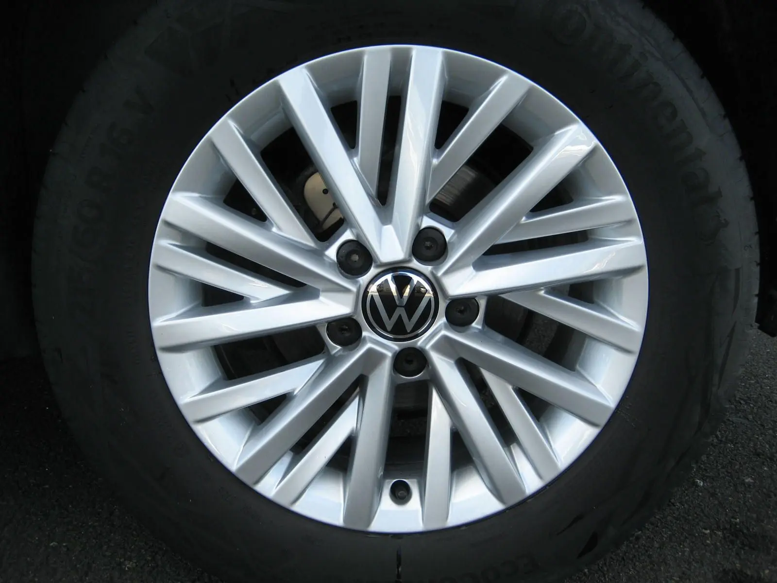 Gros plan sur la jante alliage argentée du Volkswagen T-Roc 2023, avec logo VW au centre.