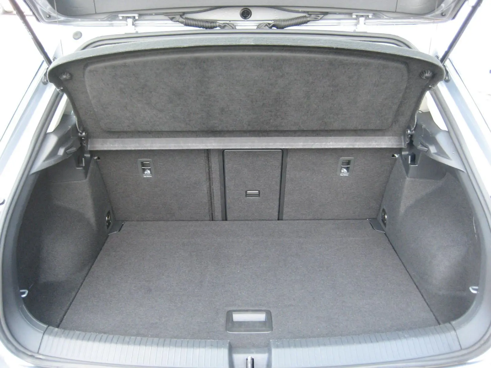 Coffre ouvert du Volkswagen T-Roc gris clair 2023, montrant un espace de chargement propre et bien agencé.