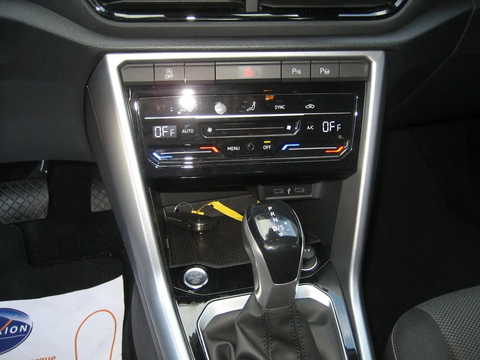 Vue rapprochée de la console centrale du Volkswagen T-Roc 2023, montrant la boîte auto DSG et les commandes de climatisation.