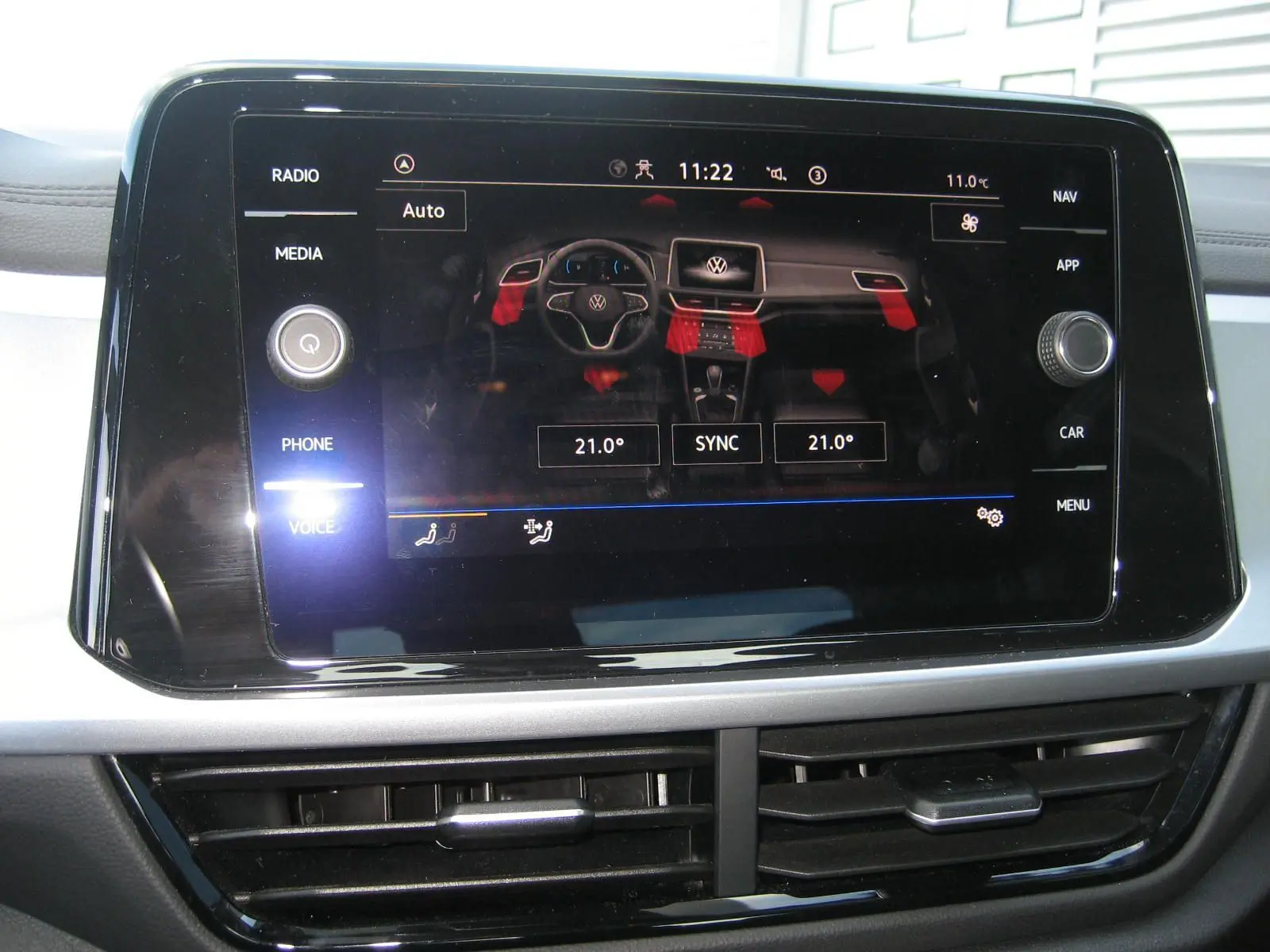 Écran tactile central du Volkswagen T-Roc 2023 affichant les réglages de climatisation à 21°C, intérieur gris clair.