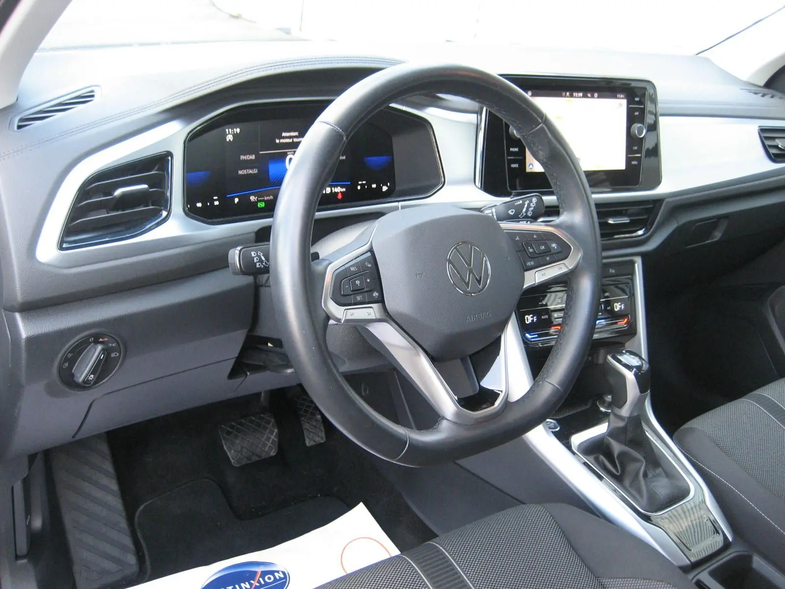 Vue intérieure du tableau de bord et volant du Volkswagen T-Roc 2023, avec écran tactile et commandes au volant.