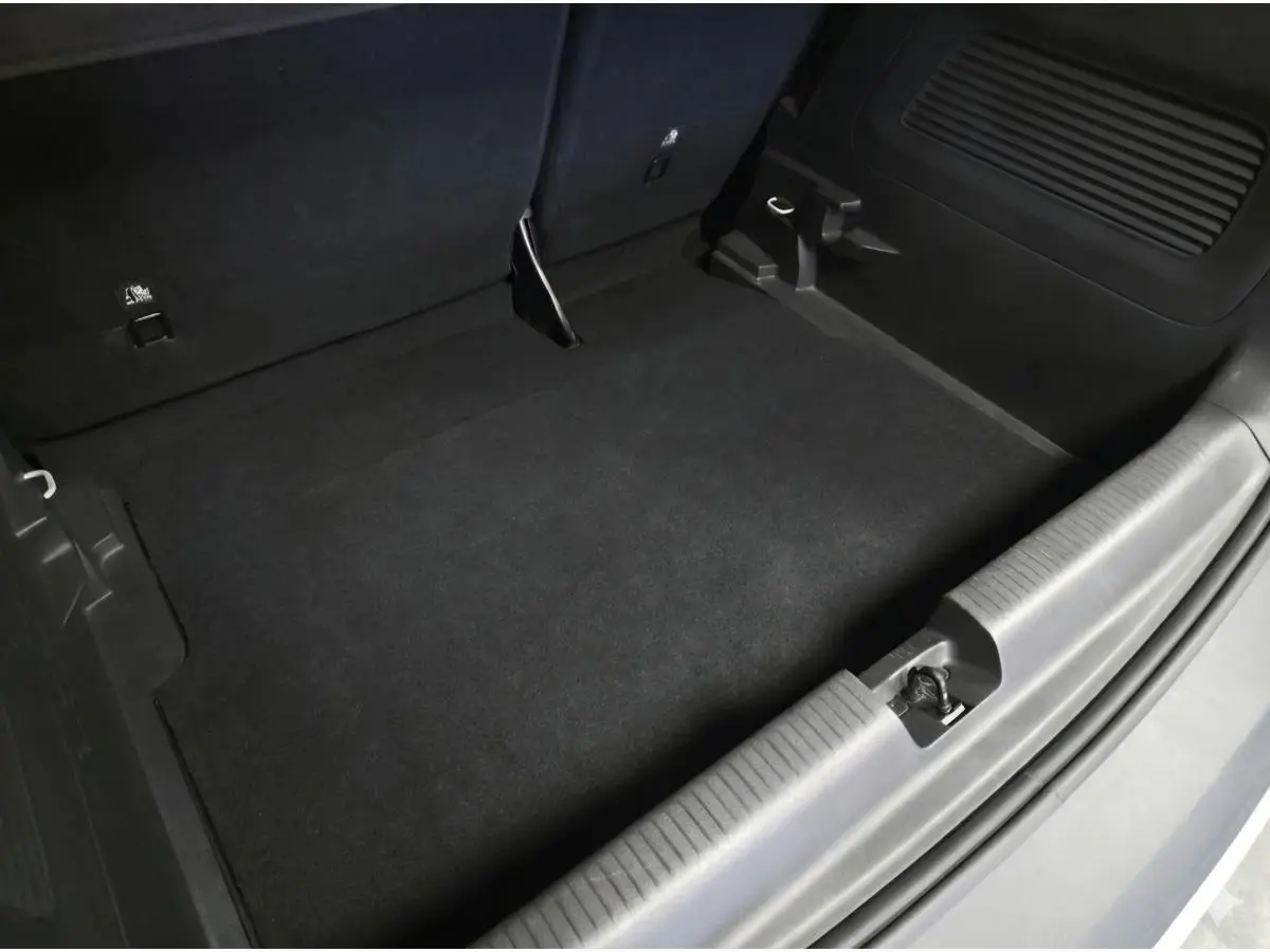 Vue rapprochée du coffre vide de l’Opel Crossland gris, montrant le revêtement noir et les fixations Isofix.