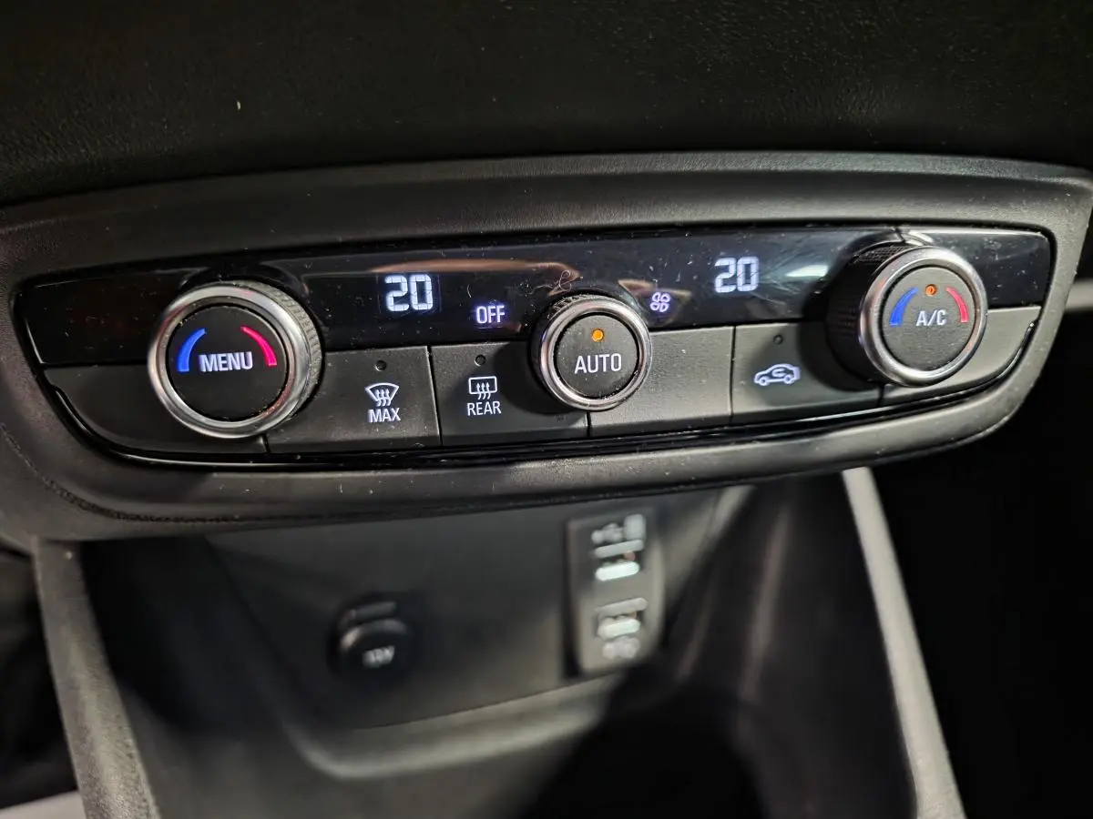 Vue rapprochée du tableau de bord de l’Opel Crossland 2023, montrant la climatisation automatique bi-zone avec réglages numériques.