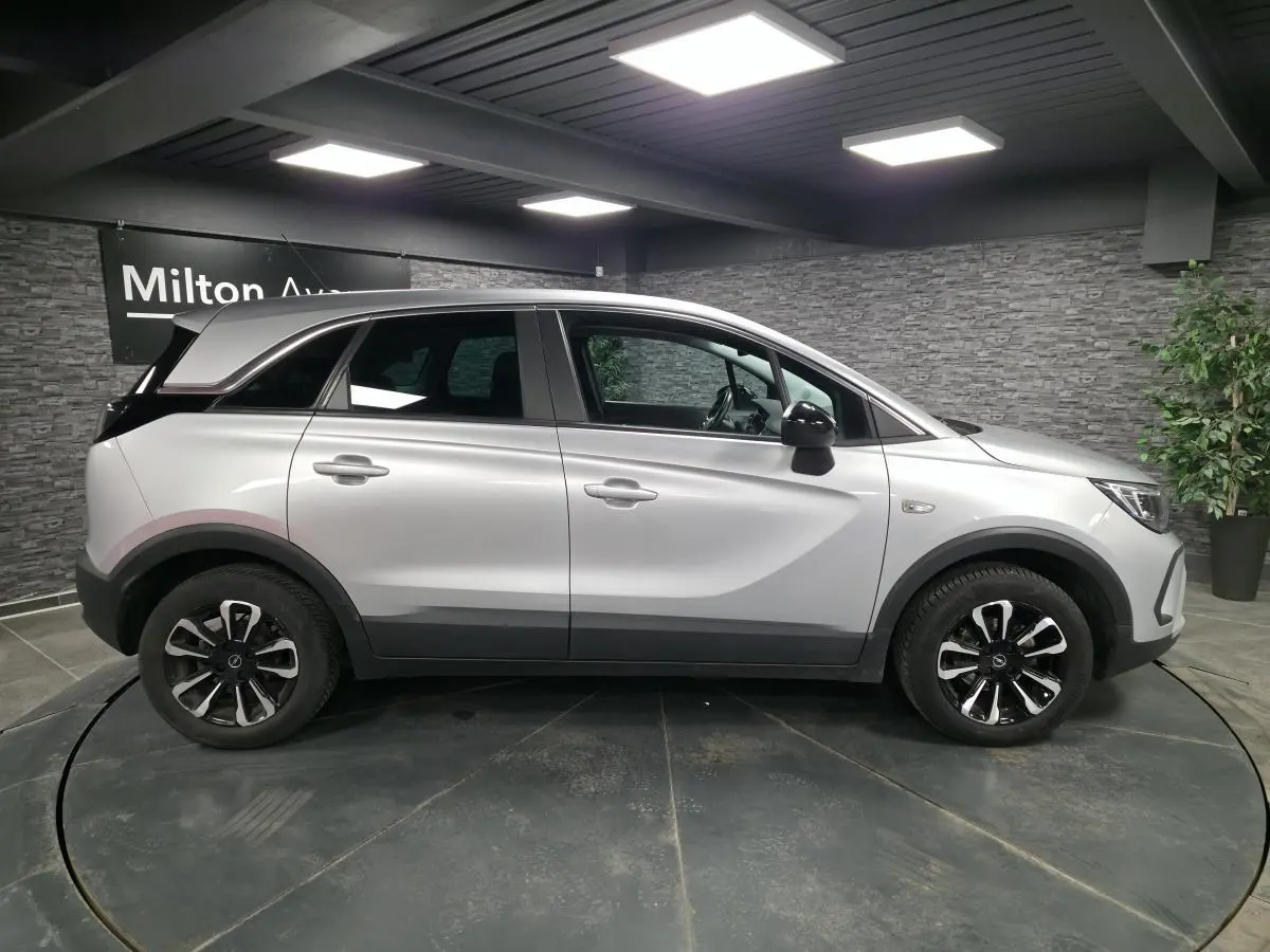 Opel Crossland gris métallisé vue de profil côté gauche avec jantes alliage noires et coques de rétroviseurs noir Karbon.