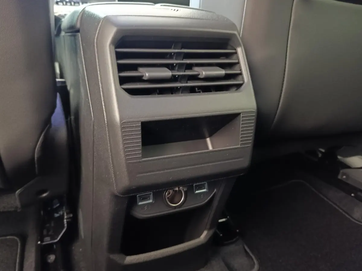 Vue rapprochée de la console arrière noire avec aérateurs et prises USB du Citroën C5 hybride vert 2026.