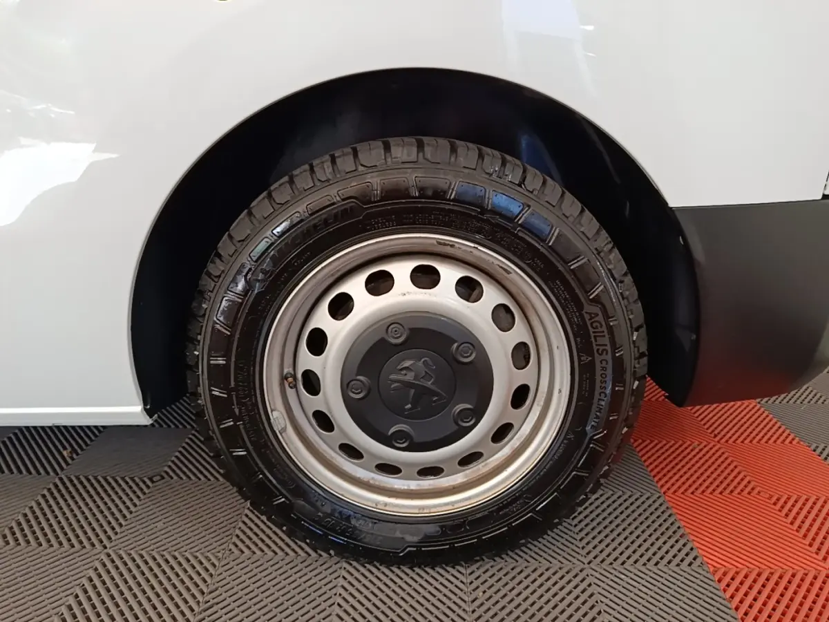 Gros plan sur la roue arrière droite blanche du Peugeot Expert Fourgon 2023 avec jante acier et logo Peugeot central.