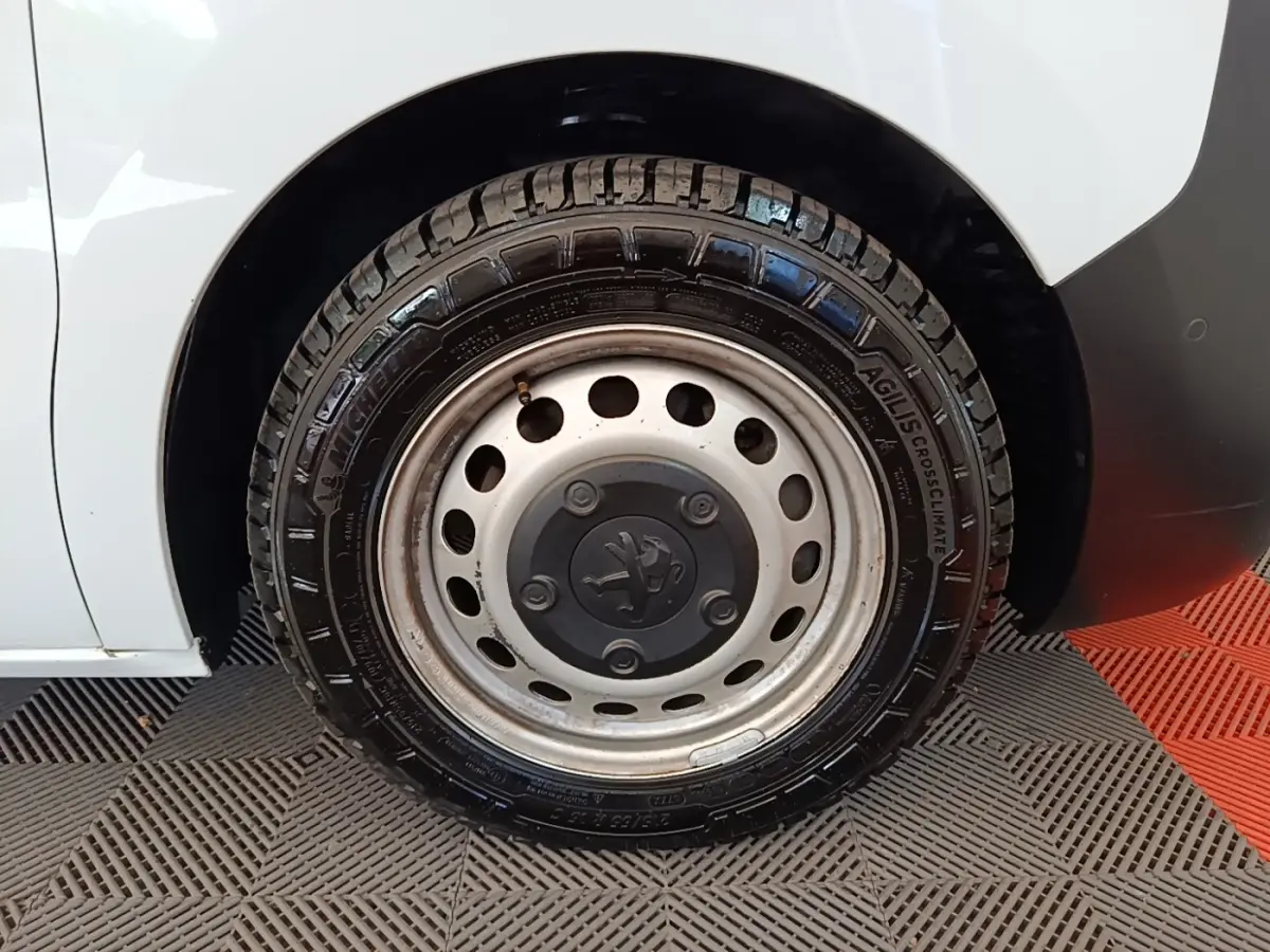 Gros plan sur la roue arrière droite blanche du Peugeot Expert Fourgon avec jante acier et logo Peugeot central.