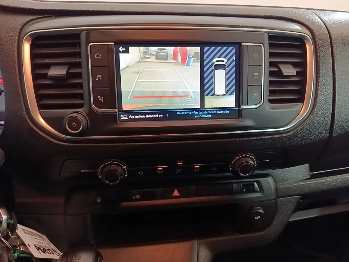Vue rapprochée de l’écran tactile central du Peugeot Expert Fourgon blanc 2023 montrant l’aide au stationnement arrière.