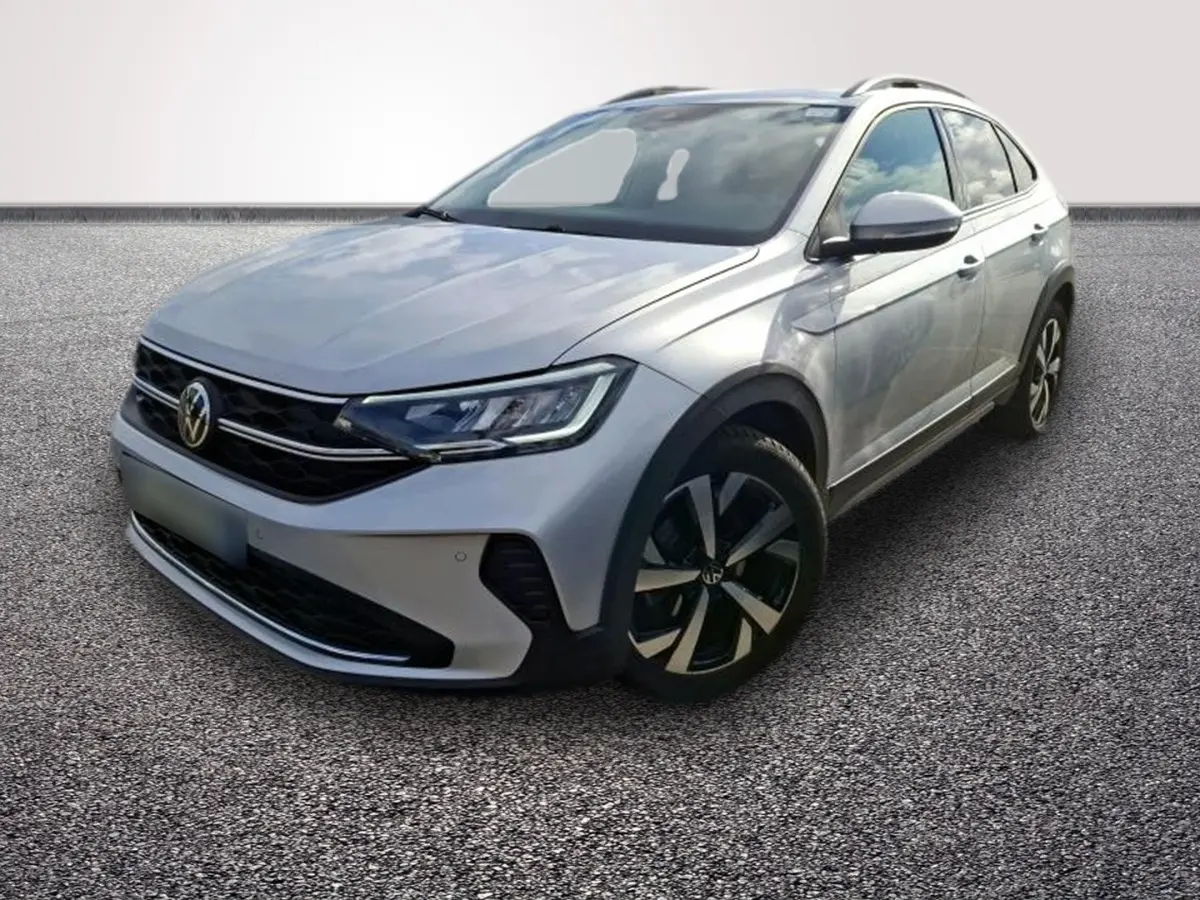 Volkswagen Taigo gris clair vu en 3/4 avant droit, avec jantes noires et phares LED distinctifs.