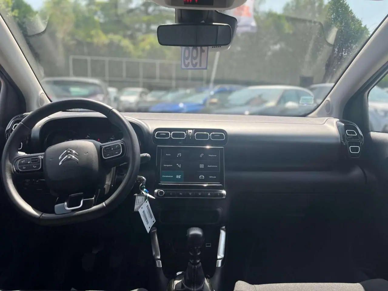 Vue intérieure frontale du tableau de bord noir du Citroën C3 Aircross 2023 avec volant multifonction et écran tactile central.