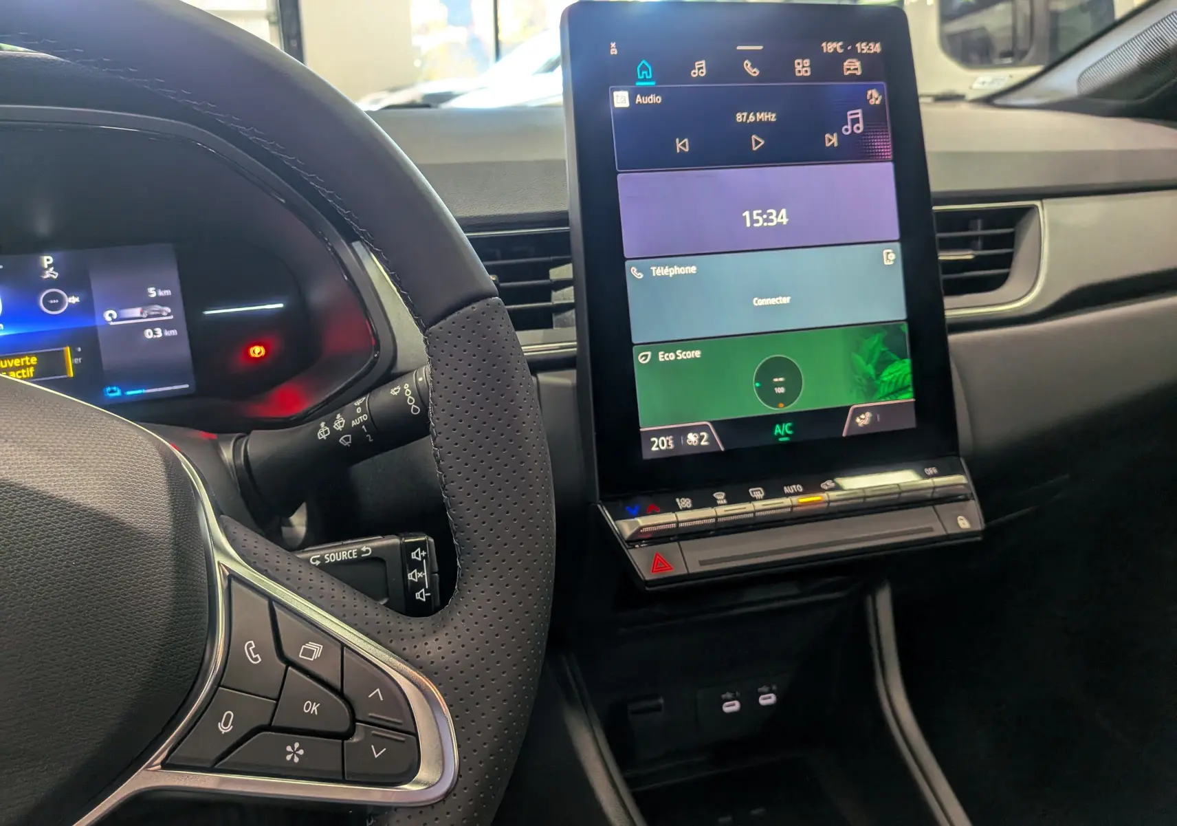 Vue intérieure du tableau de bord du Renault Captur E-TECH 2025, avec écran tactile central et volant multifonction.