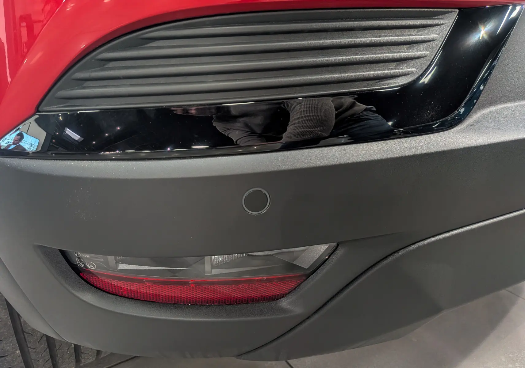 Gros plan sur le feu arrière et le pare-chocs noir du Renault Captur E-TECH rouge Flamme, version 2025.