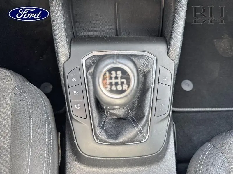 Vue plongeante sur le levier de vitesse manuel en cuir de la Ford Focus 1.0 EcoBoost rouge avec sièges tissu gris.